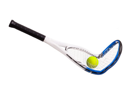Broken tennis racquet with tennis ball going through the strings on a black backgroundの写真素材
