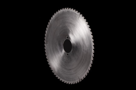 Massive circular steel saw blade isolated on a black background. Industrial machine part with copy spaceの写真素材