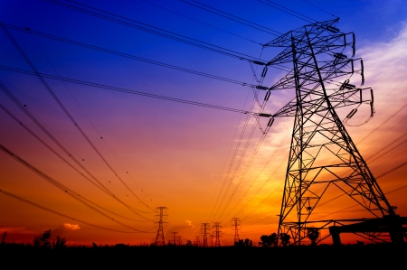 Silhouette electricity pylons during sunsetの写真素材