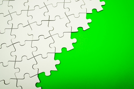 Jigsaw puzzle on green backgroundの写真素材