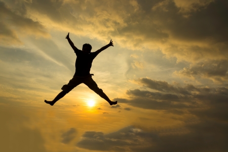 Silhouette of man jumping during sunset の写真素材