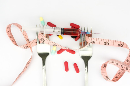 Steel spoon a fork, syringe and measuring tape with shallow depth of field (dof) - risk diet and healthy conceptの写真素材