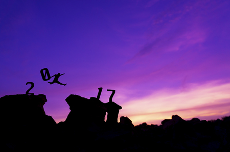 Silhouette man jumping and brings number '0' to complete 2017 years.の写真素材