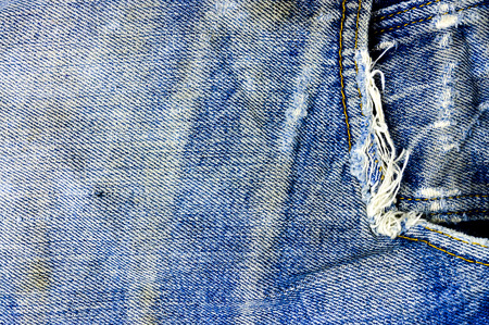 Torn and shabby old blue jeans backgroundの写真素材