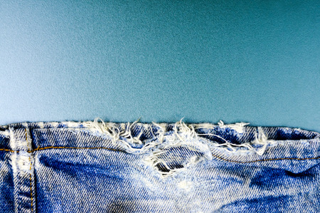 Torn and shabby old blue jeans background