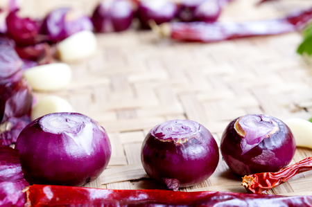 Collection of fresh onions and chilis on the bamboo matt with depth of field (DOF) effect. Top view and copy space.の写真素材