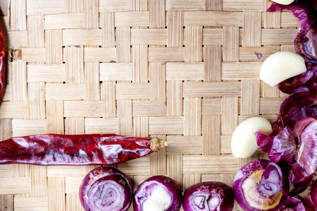 Collection of fresh onions and chilis on the bamboo matt with depth of field (DOF) effect. Top view and copy space.の写真素材