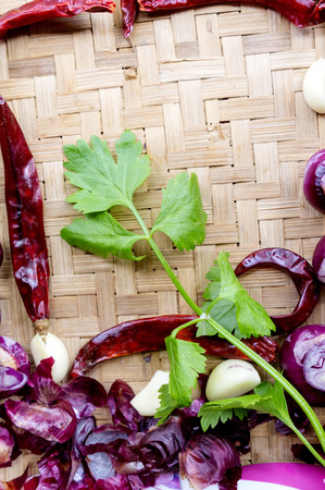 Collection of fresh onions and chilis on the bamboo matt with depth of field (DOF) effect. Top view and copy space.の写真素材