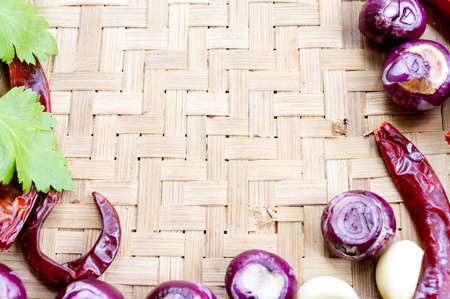 Collection of fresh onions and chilis on the bamboo matt with depth of field (DOF) effect. Top view and copy space.の写真素材