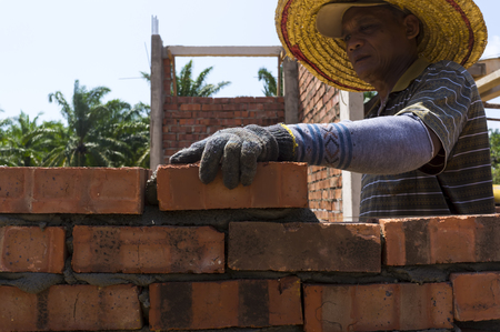 PAHANG,MALAYSIA - March 25,2017: Unidentified man doing Bricklayer lay clay bricks to form building walls at the construction site.のeditorial素材
