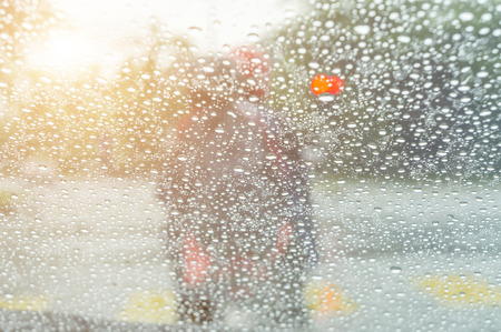 Driving in rain at sunset. Road view through car window with rain drops.の写真素材