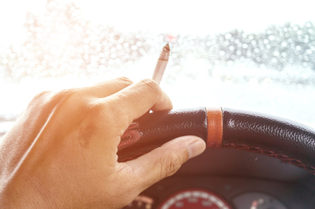 Close up hand handle cigarette. Smoking and driving.の写真素材