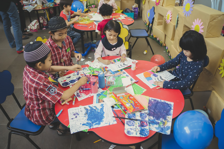 KUALA LUMPUR, MALAYSIA - NOVEMBER 5, 2016 : Group of cute little preschool kids drawing with colorful pencils.のeditorial素材