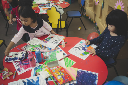 KUALA LUMPUR, MALAYSIA - NOVEMBER 5, 2016 : Group of cute little preschool kids drawing with colorful pencils.のeditorial素材
