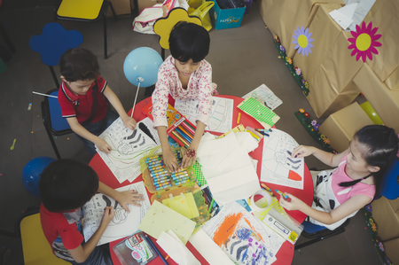 KUALA LUMPUR, MALAYSIA - NOVEMBER 5, 2016 : Group of cute little preschool kids drawing with colorful pencils.のeditorial素材