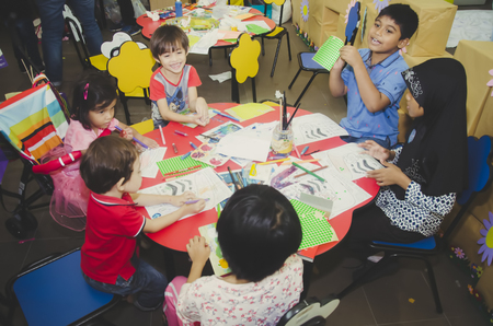 KUALA LUMPUR, MALAYSIA - NOVEMBER 5, 2016 : Group of cute little preschool kids drawing with colorful pencils.のeditorial素材