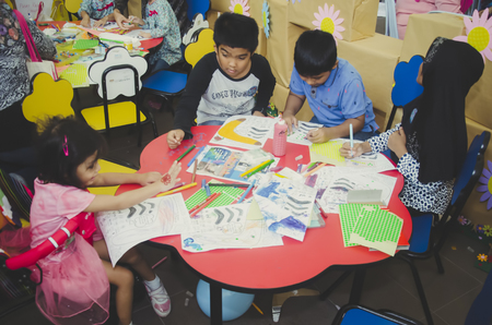 KUALA LUMPUR, MALAYSIA - NOVEMBER 5, 2016 : Group of cute little preschool kids drawing with colorful pencils.のeditorial素材