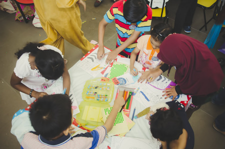 KUALA LUMPUR, MALAYSIA - NOVEMBER 5, 2016 : Group of cute little preschool kids drawing with colorful pencils.のeditorial素材