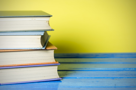 Closeup hardcover book isolated on yellow background. Selective focus.の写真素材