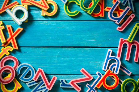 Close up arrangement of alphabet on blue background. Copy-space, preschool, education concept or other your content. Long shadow and vignette effect.の写真素材