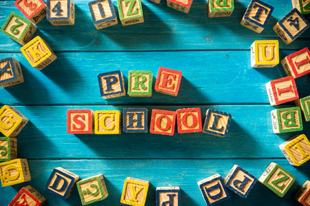 Close up arrangement of "Preschool" alphabet on blue background. Preschool, education concept or other your content. Long shadow and vignette effect.の写真素材
