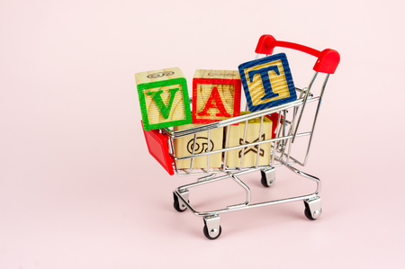 VAT (Value-Added Tax) on household goods concept. Trolley with alphabet (V.A.T) block.の写真素材