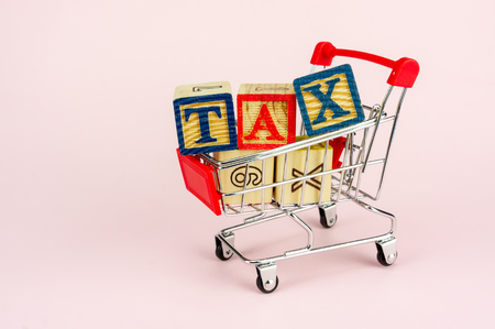 TAX and Taxation on household goods concept. Trolley with alphabet (T.A.X) block.の写真素材