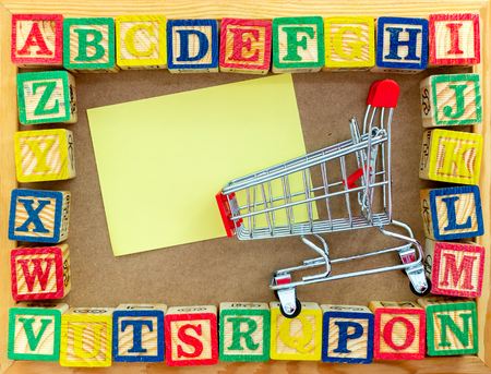 Alphabet blocks with trolley and copy-space. Stationary shopping and back to school concept. Pre-school concept.の写真素材