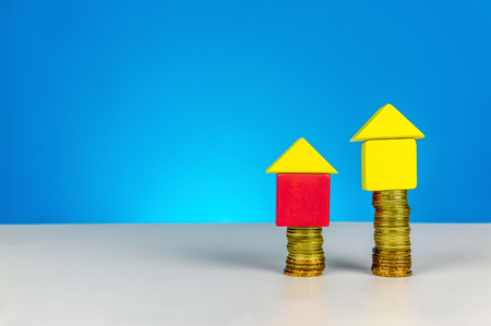 Saving for dream house. Build a house from wood cubes with stacking coin. Real estate, investment, property planning concept or other your content.の写真素材