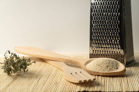 bread crumbs in a wooden spoon with a grater scratchの写真素材