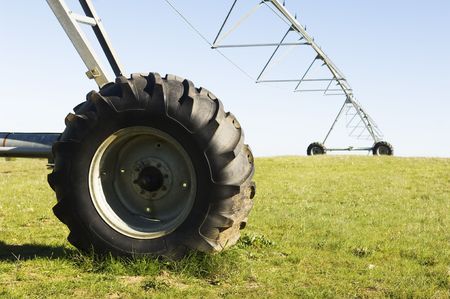 Resting irrigation pivot in a green grass field.