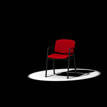 Empty Red Chair under Spotlight on Dark Backgroundの写真素材