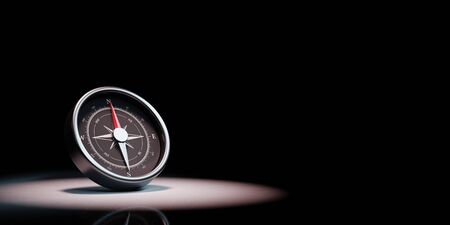 Metallic Compass with Red Magnetic Needle Pointing Toward the North Spotlighted on Black Background with Copy Space 3D Illustrationの写真素材