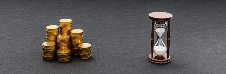 Heaps of Coins and Hourglass on Dark Backgroundの写真素材