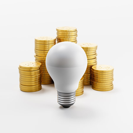 LED Light Bulb ahead of Stacks of Coins on Light Gray Backgroundの写真素材