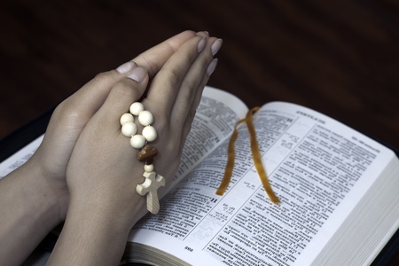 holy bible and cross on a wooden brown background