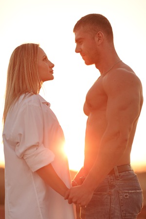 Portrait of a loving couple against a beautiful sunsetの写真素材