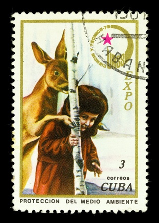 CUBA - CIRCA 1975: A Stamp shows a boy and a deer in winter in the tree.の写真素材