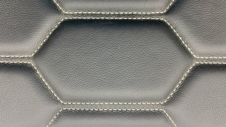 Leather stitched with white hexagon or honeycomb black texture or background.