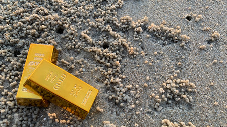 view of gold bars and sandy soil background, suitable for wealth or investment, photo concept