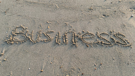 Business written in sand offers an optimistic message of new beginnings and opportunity in the digital landscapeの写真素材