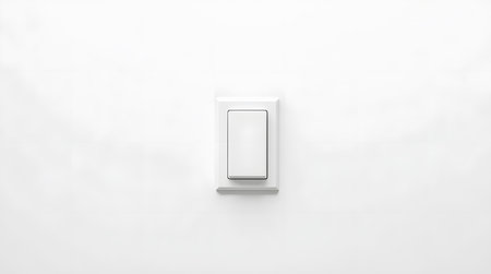 Minimalist light switch on white wall offers clean energy efficiency and modern design appeal for sustainable livingの素材