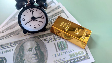 mini clock, gold bars and usd banknotes, investment or savings, photo conceptの写真素材