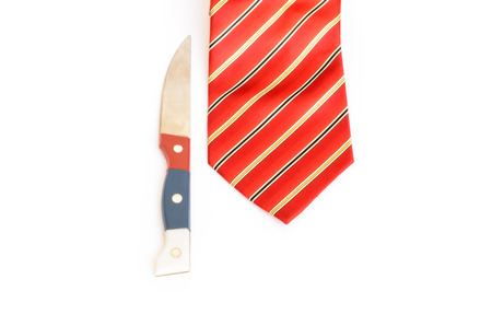 Closeup of knife and red tie on white background.の写真素材