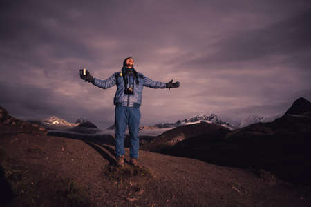 a satisfied happy trekker is enjoying the sun rise with a cup of teaのeditorial素材