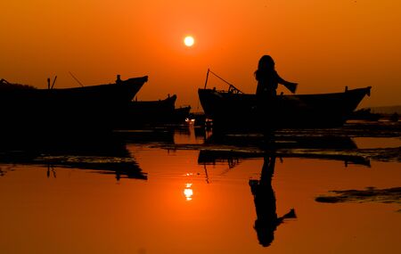 a beautiful sexy girl is standing beside a riverbed in the time of golden hourの写真素材