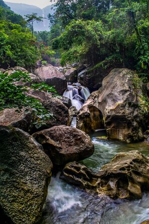 the beautiful scenic waterfall in front of famous double decker root bridge in meghalaya
