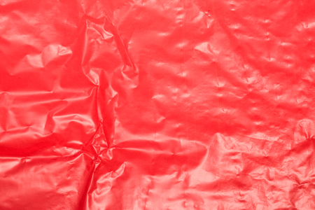 Wrinkled red plastic sheet for background or textの写真素材