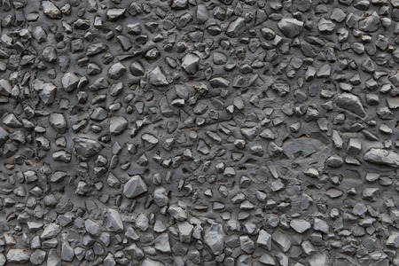 Textured concrete wall with gray, sharp stones.の写真素材