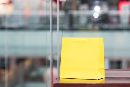Yellow gift bag in the mall with defocused background.の写真素材